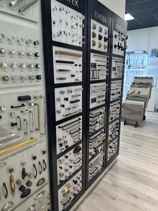 Row of black cabinet hardware display panels with pulls and knobs