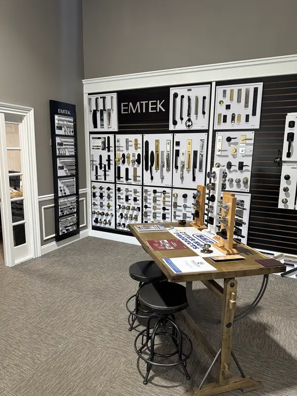 Full Emtek wall display with a hardware sample table in a dealer showroom