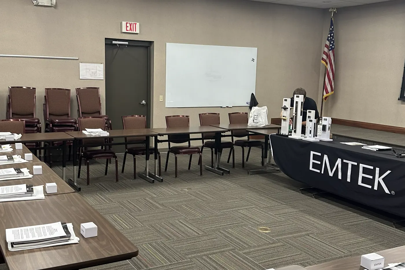A meeting room set up for an Emtek training session, with product packets and samples at every seat
